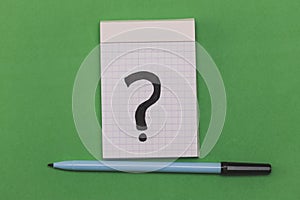 top view of a pen and a note book with a question mark drawn on it , why ? - business concept