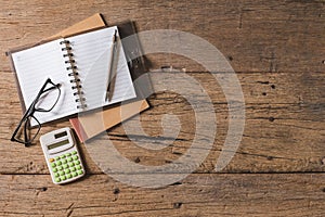 Top view Pen, notebook, glasses, calculator,  smartphone on the wooden table and copy space