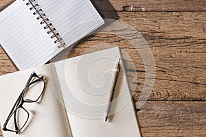 Top view of Pen, notebook, glasses, calculator,  smartphone on wooden table and copy space