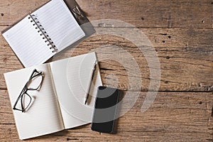 Top view of Pen, notebook, glasses, calculator,  smartphone on wooden table and copy space