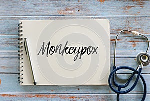 Top view of pen,stethoscope and notebook written with Monkeypox photo