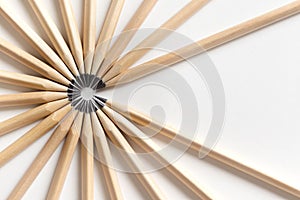 Top view of pencils made of wood lie on a white surface forming an open circle
