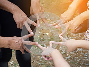 Top view of people doing a star shape with fingers showing unity and teamwork