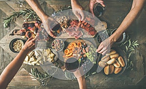 Top view of people drinking, eating together and holding glasses