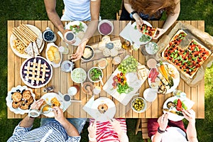 Top view on people eating lunch at garden table during party