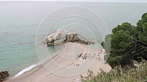 Top view of people relaxing and tanning on beach near sea in cloudy afternoon.