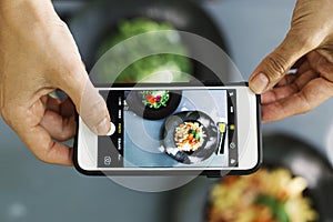 Top view of people using cellphone to take food photo