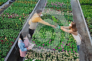 Top view of people working in greenhouse in garden center, coronavirus concept.