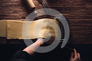 Top view of a person rolling the dough using a dough roller sheeter