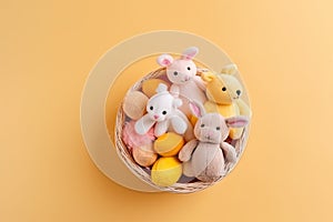 Top view photo of a basket filled with colorful Easter eggs and bunny plush toys