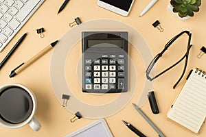 Top view photo of calculator in the middle keyboard cup of coffee flowerpot pens stationery binders glasses smartphone and