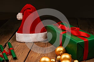 Top view photo of Christmas Flatlay gift box and Christmas tree decorations. Santa hat on a wooden backgroundon