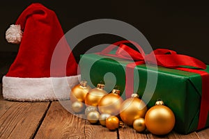 Top view photo of Christmas Flatlay gift box and Christmas tree decorations. Santa hat on a wooden backgroundon