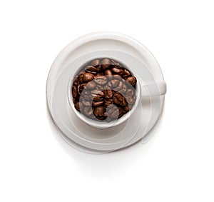Top View Photo of a Coffee cup filled with coffee beans and saucer isolated on white background