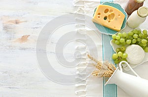 Top view photo of dairy products over white wooden background. Symbols of jewish holiday - Shavuot
