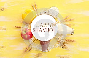 Top view photo of dairy products over yellow wooden background. Symbols of jewish holiday - Shavuot