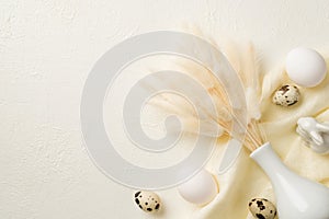 Top view photo of easter decorations white vase with lagurus flowers ceramic easter bunny quail eggs and cloth on isolated white