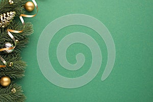 Top view photo of gold and silver christmas tree balls toy cone small bells and serpentine on pine twigs on isolated green