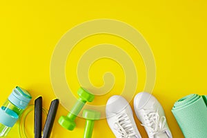 Top view photo of green dumbbells, skipping rope, exercise mat, bottle of water and white sports shoes