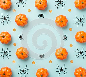 Top view photo of halloween decorations composition pumpkin silhouettes and spiders on isolated pastel blue background with blank