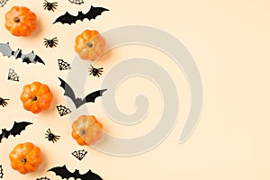 Top view photo of halloween decorations small pumpkins spiders cobweb and bats silhouettes on isolated beige background with