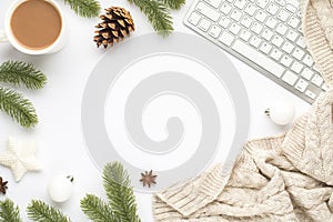 Top view photo of keyboard cup of hot drinking white christmas tree decorations balls star pine twigs cone anise and scarf on