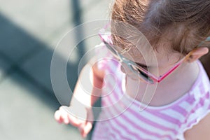 Top view photo of a little girl in sunglasses and pigtails closeup