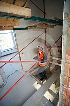 Top view photo of male construction inspector walking up stairs