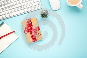 Top view photo of notebook pen giftbox with red bow keyboard computer mouse pine toy and cup of hot drinking on isolated pastel