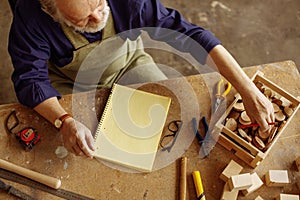 Top view photo of old master working with crossed-sections of a tree