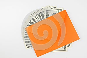 Top view photo of orange envelope and heap of dollars on white