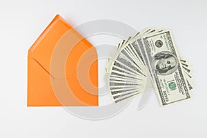 Top view photo of orange envelope and heap of dollars on white