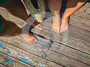 Top view, photo of a pair of bare feet on a wooden old floor. Photos on vacation, beach, summer