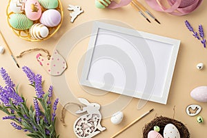 Top view photo of photo frame paintbrushes colorful easter eggs bowl wooden bunnies chicken pink ribbon nest lavender flowers