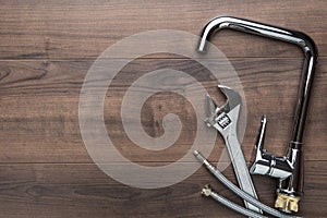 Top view photo of plumbing tools over wooden background with copy space.