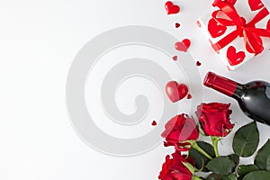 Top view photo of red roses, wine bottle, gift box and red hearts