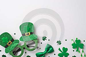 Top view photo of the shimmer Irish spectacles with hats silk green bow tie two stripped straws and green confetti in shape of