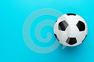 Top view photo of soccer ball over turquoise blue background with copy space.