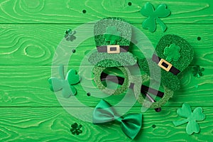 Top view photo of st patrick`s day decorations shamrocks trefoil shaped confetti funny outfit hat shaped party glasses and green