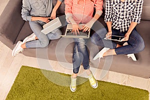 Top view photo of three girls working on laptop and digital tablet