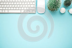 Top view photo of white keyboard computer mouse pine toys and white christmas tree balls on isolated pastel blue background with