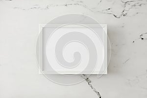 Top view photo of white marble background and frame in the middle.