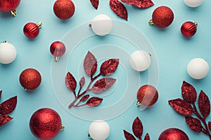 Top view photo of white and red christmas tree decorations balls and branches on isolated pastel blue background