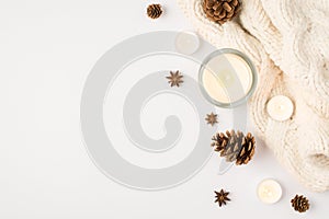 Top view photo of winter composition lighted candles white knitted scarf pine cones and anise on isolated white background with