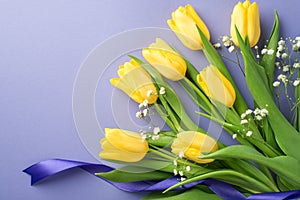 Top view photo of woman`s day composition bunch of yellow tulips white gypsophila and purple ribbon on isolated pastel violet