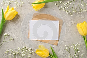 Top view photo of woman`s day composition craft paper envelope and paper sheet yellow tulips and white gypsophila on isolated