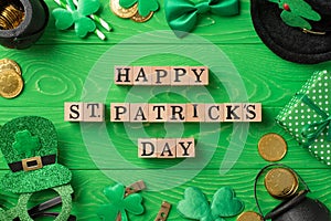 Top view photo of wooden cubes with words happy st patricks day party glasses leprechaun hat straws bow-tie giftbox horseshoe
