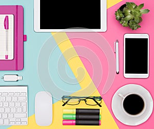 Top view photo of workspace with blank mock up tablet and smartphone, coffee cup, keyboard, notepad and succulent plant.