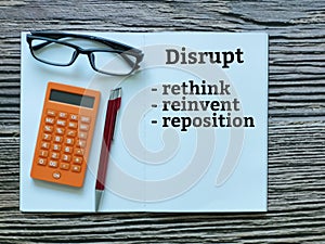 Top view phrase disrupt,rethink,reinvent,reposition written on notebook