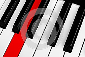 Top view of piano keys with one red button. Close-up of piano keys. Close frontal view. Piano keyboard with selective focus. Diago